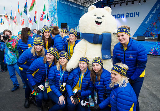 Spelare ur damkronorna poserar med en maskot när Sverige