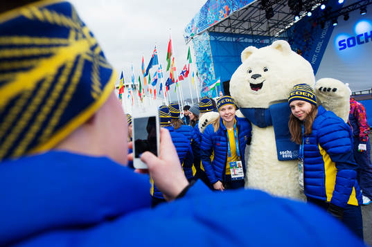 Spelare ur damkronorna poserar med en maskot när Sverige