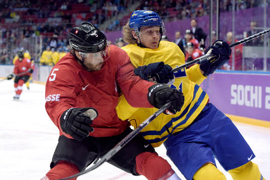 Schweiz Severin Blindenbacher tacklar Sveriges Carl Hagelin
