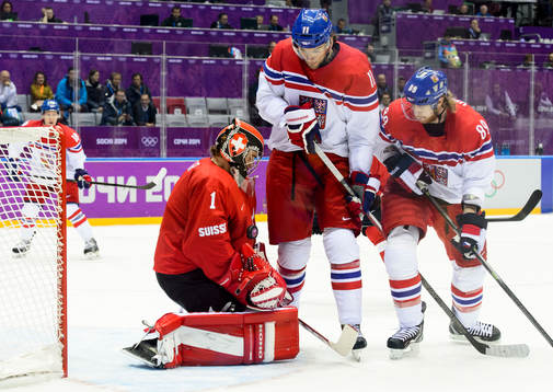 Schweiz målvakt Jonas Hiller med pucken framför Tjeckiens