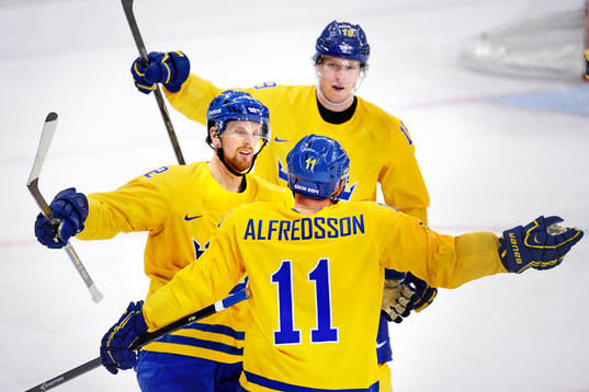 Daniel Alfredsson gratuleras av Daniel Sedin (tv) och