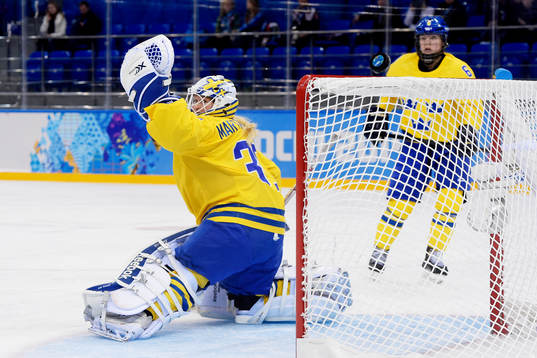 En puck flyger över Sveriges målvakt Kim Martin Hasson