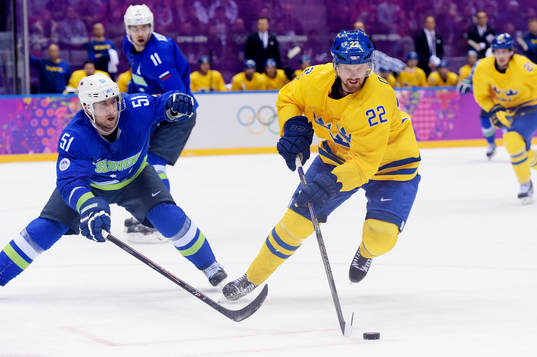 Sloveniens Mitja Robar kämpar för pucken med Sveriges