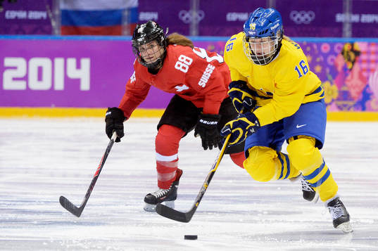 Sveriges Pernilla Winberg åker med pucken och Schweiz