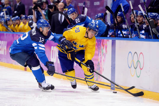 Sveriges Alexander Steen kämpar för pucken med Finlands