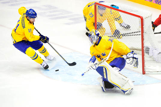 Sveriges Daniel Alfredsson rensar undan pucken framför