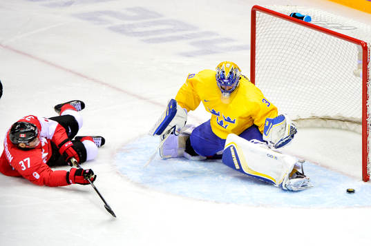 Kanadas Patrice Bergeron faller framför Sveriges målvakt