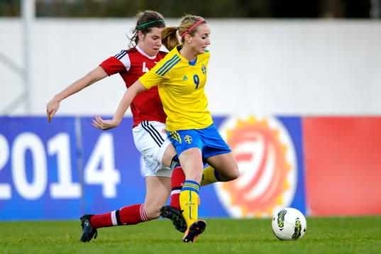 Sveriges Kosovare Asllani får en spark på benen av