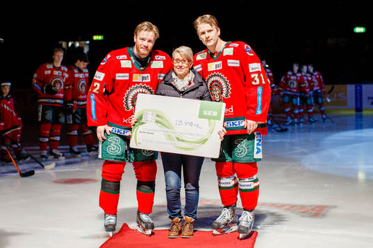 Tobias Oskarssons mamma tar emot en check av Frölundas