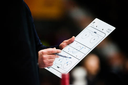 Djurgårdens tränare instruerar spelarna på en taktiktavla