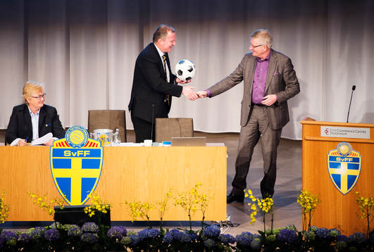 Karl-Erik Nilsson, ordförande, tar emot en fotboll av Hans