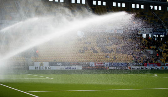 Vattning av konstgräs innan fotbollsmatchen i Svenska