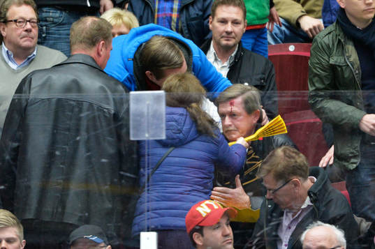 En man i publiken träffas av pucken i huvudet