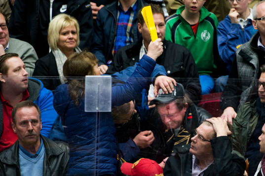 En man i publiken träffas av en puck