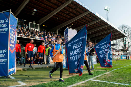 Lagen marscherar in på planen innan fotbollsmatchen i