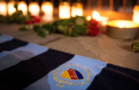 En halsduk med Djurgårdens emblem ligger framför tända