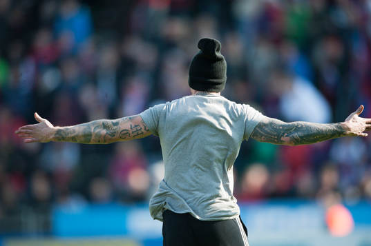 En Djurgården-supporter springer in på plan i matchen i