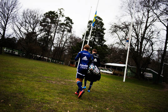 Djurgårdens spelare lämnar planen och en svensk flagga