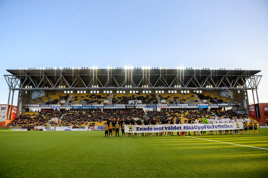 Spelarna håller upp en banderoll med texten "Enade mot