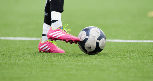 Fotboll och fotbollsskor Adidas på konstgräs i DM-matchen