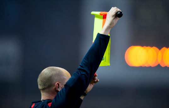 Assisterande domare signalerar för byte i matchen i
