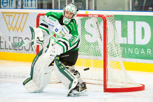 Rögles målvakt Kevin Lindskoug ser en puck flyga förbi