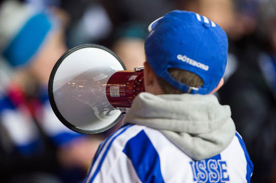 En ung blåvitt-supporter med megafon