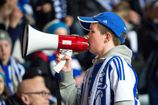 En ung blåvitt-supporter med megafon