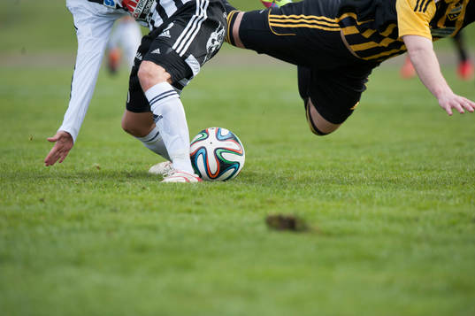 Kamp om bollen, ben, fotbollsskor, fotbollsstrumpor i