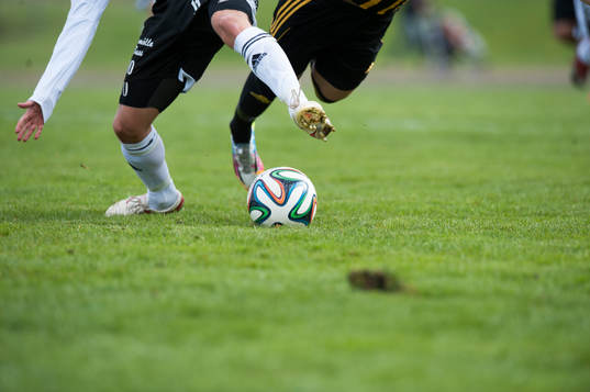 Kamp om bollen, ben, fotbollsskor, fotbollsstrumpor i