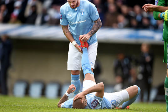 Malmö FFs Magnus Eriksson hjälper Guillermo Molins som