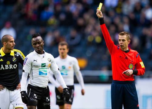 Örebros Samuel Mensiro får ett gultkort av domare Johan