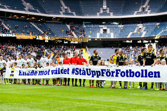 s spelare visar upp en banderoll med texten "Enade mot
