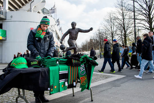 En souvenirförsäljare utanför arenan innan