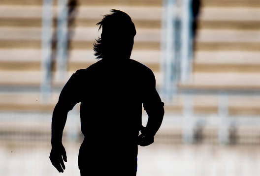 En fotbollsspelare springer i siluett