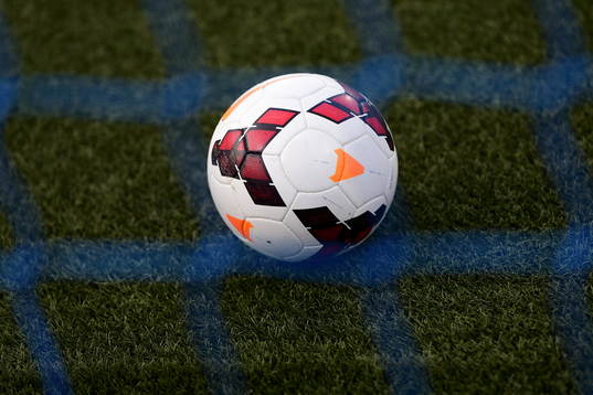 Fotboll bakom målnät