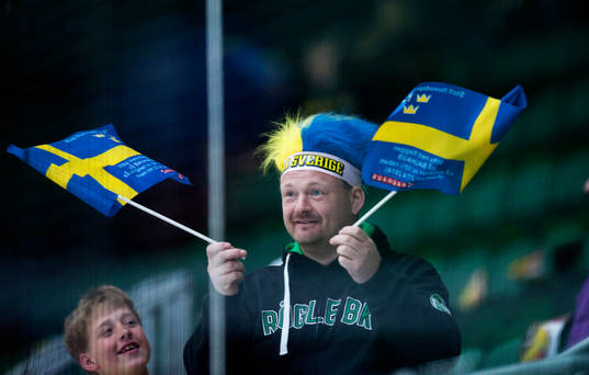 Svensk supporter med svenska flaggor i ishockeylandskampen