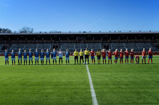 Djurgårdens spelare och QBIKs spelare ställer upp sig på