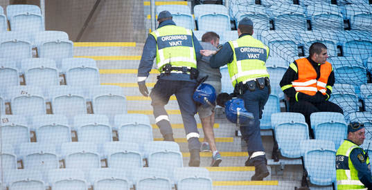 Ordningsvakter tar hand om en supporter i semifinalen i