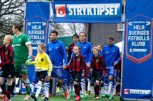 Spelare går in på planen innan fotbollsmatchen i