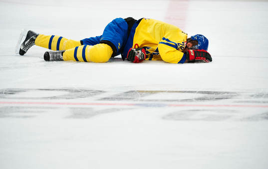 Sveriges Dick Axelsson ligger på isen skadad