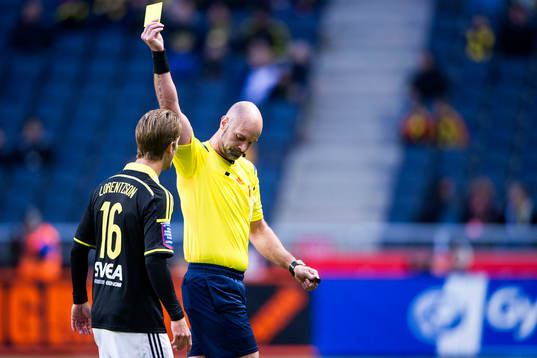 s Martin Lorentzson får ett gult kort av domare Stefan