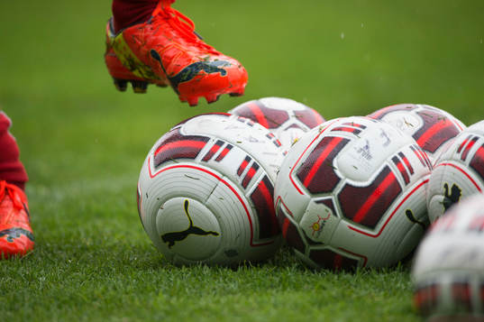 Fotbollssko och bollar i det våta gräset vid Helsingborgs