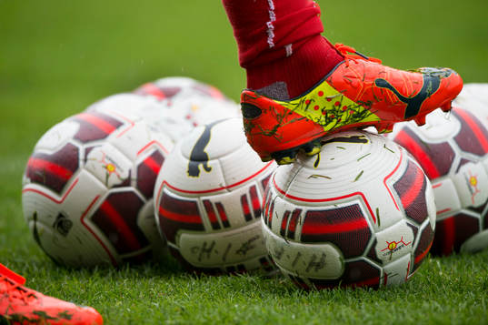 Fotbollssko och bollar i det våta gräset vid Helsingborgs