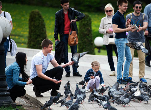 Människor leker med duvor i centrala Minsk