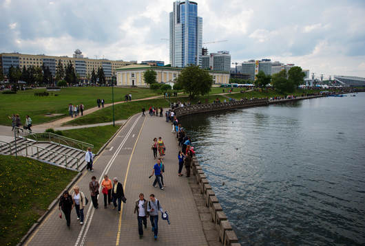 Människor promenerar utmed en flod i centrala Minsk