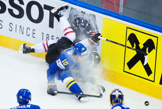 Kanadas Mark Scheifele blir tacklad av Sveriges Johan
