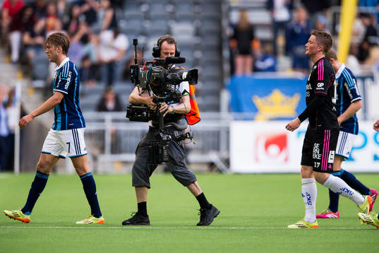 En kameraman följer spelarna på väg av planen