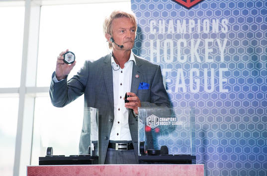 s ordförande Anders Ternbom håller upp en puck för