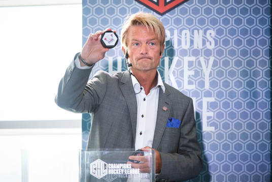 s ordförande Anders Ternbom håller upp en puck för
